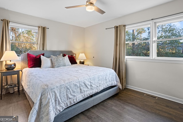 bedroom with visible vents, dark wood finished floors, baseboards, and ceiling fan