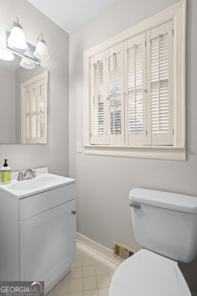 bathroom with visible vents, toilet, vanity, tile patterned flooring, and baseboards