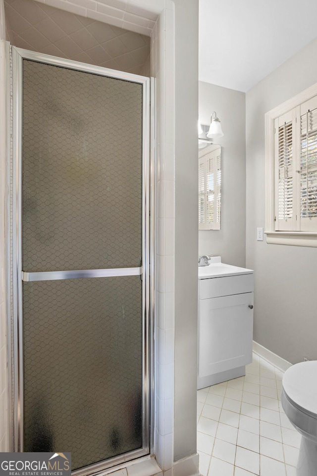 full bathroom featuring toilet, a shower stall, vanity, tile patterned flooring, and baseboards