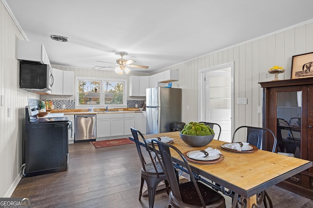 dining area featuring ornamental molding, dark wood-style flooring, visible vents, and ceiling fan