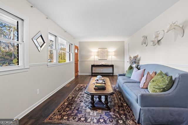 living area featuring dark wood-style floors, visible vents, and baseboards