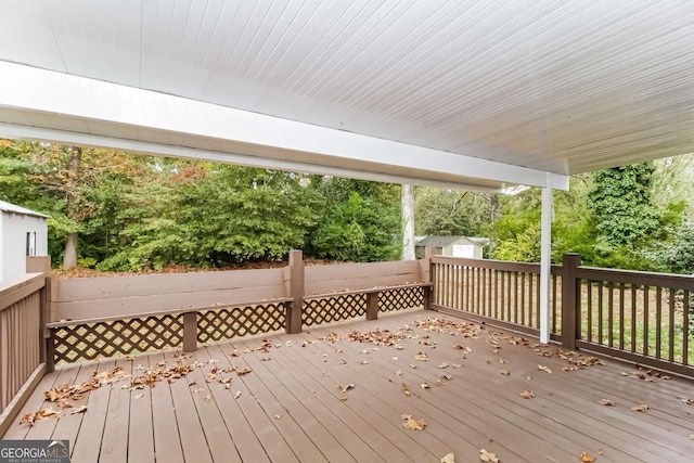 wooden deck with a storage unit and an outdoor structure