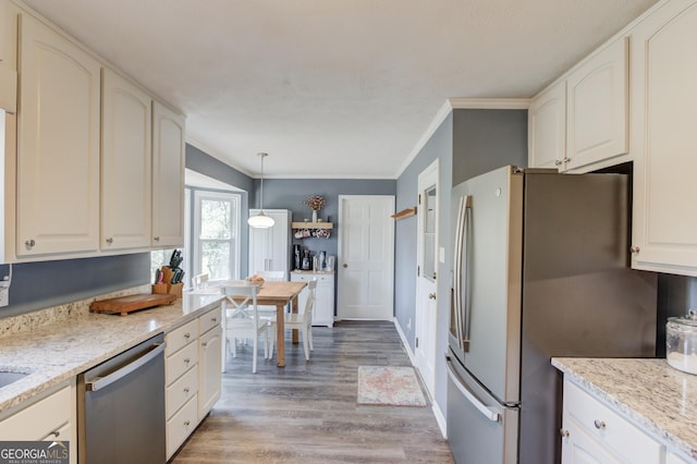 kitchen featuring light stone counters, appliances with stainless steel finishes, light wood-style flooring, and crown molding