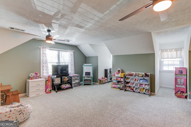 rec room featuring carpet, a textured ceiling, visible vents, and a ceiling fan