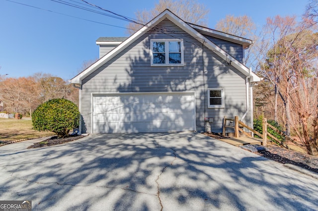 view of property exterior featuring a garage and concrete driveway