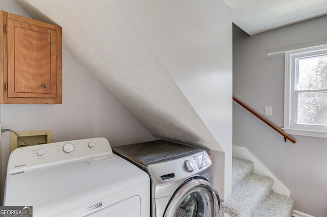 laundry area with cabinet space, independent washer and dryer, and baseboards