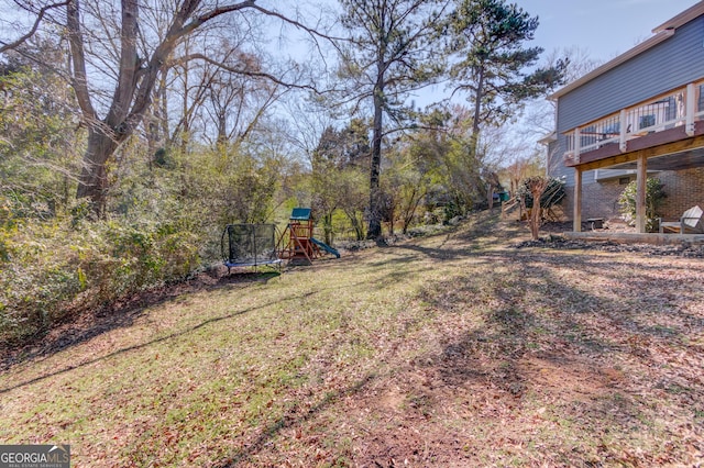 view of yard featuring a trampoline and a playground