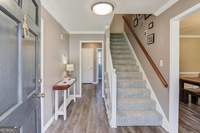 entrance foyer with stairs, baseboards, crown molding, and wood finished floors