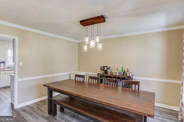 dining space with ornamental molding, baseboards, an inviting chandelier, and wood finished floors