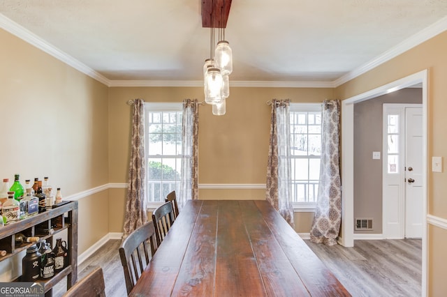 dining room with baseboards, visible vents, a wealth of natural light, and wood finished floors