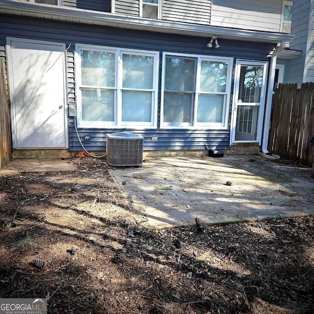 entrance to property featuring fence and central AC unit