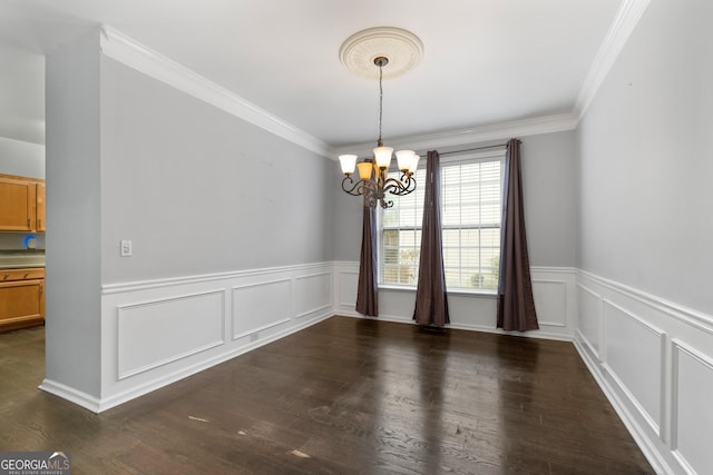 unfurnished dining area with dark wood-style floors, wainscoting, crown molding, and a notable chandelier