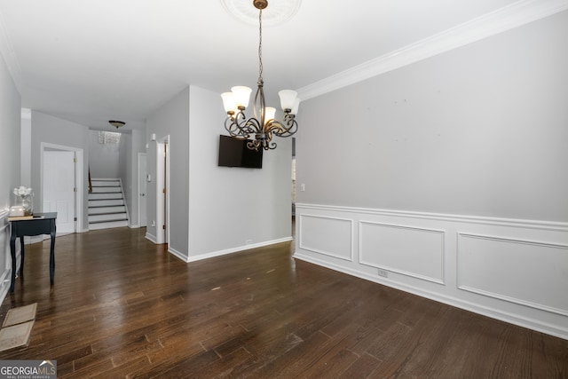 unfurnished dining area with a chandelier, a decorative wall, ornamental molding, stairway, and dark wood finished floors