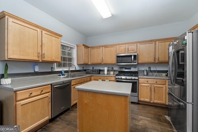 kitchen with stainless steel appliances, a center island, dark wood finished floors, and a sink