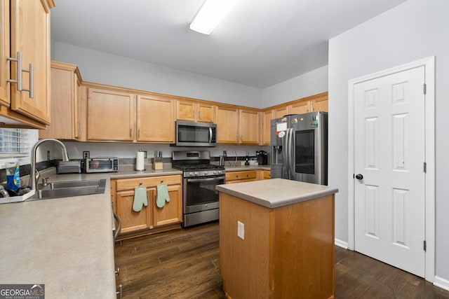 kitchen with dark wood-style flooring, a sink, light countertops, appliances with stainless steel finishes, and a center island