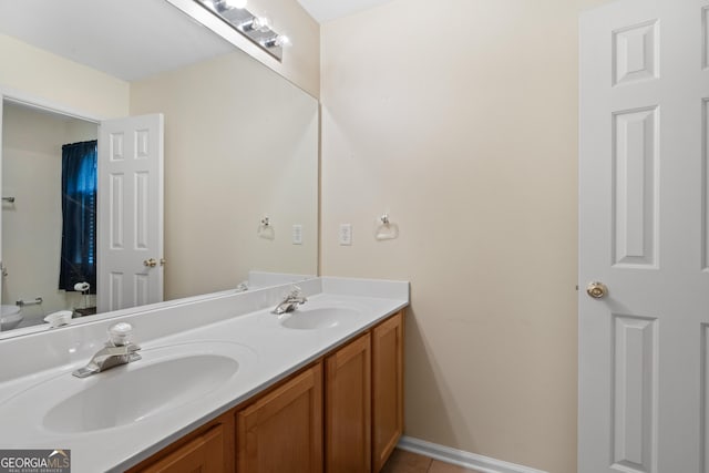 full bath featuring tile patterned flooring, a sink, toilet, and double vanity