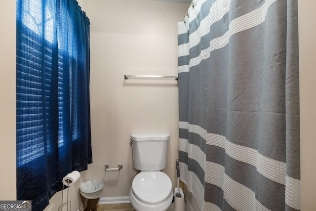 bathroom with baseboards and toilet