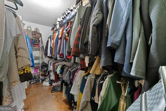 walk in closet with wood finished floors