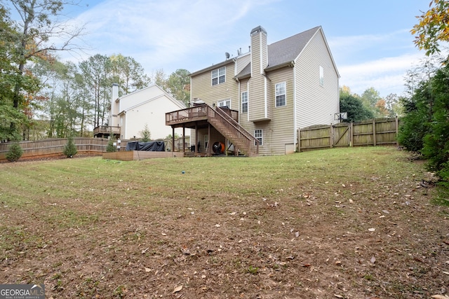 rear view of property featuring a fenced backyard, a gate, stairway, and a wooden deck