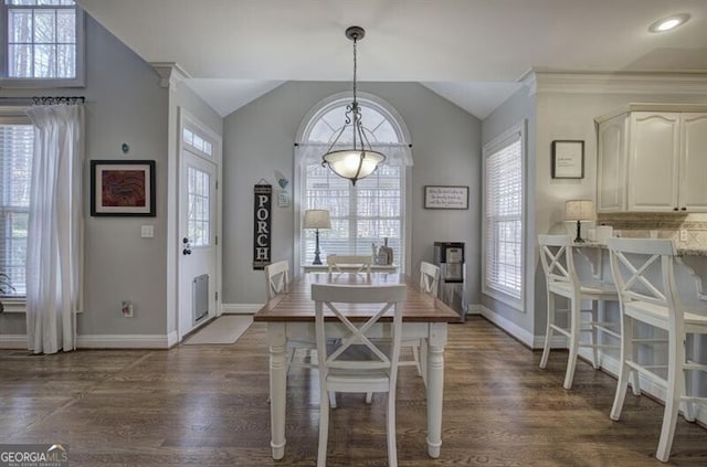 dining space with plenty of natural light, vaulted ceiling, and dark wood-style flooring