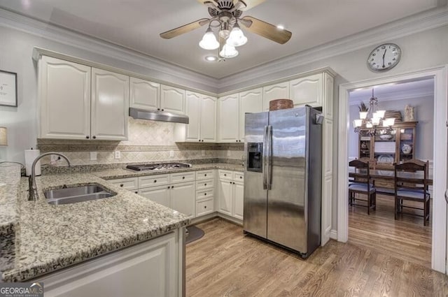 kitchen featuring light stone counters, light wood-style flooring, under cabinet range hood, stainless steel appliances, and a sink