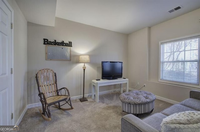 living room with baseboards, visible vents, and carpet flooring