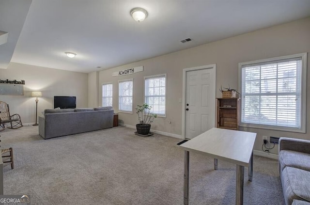 living room with carpet floors, visible vents, and baseboards