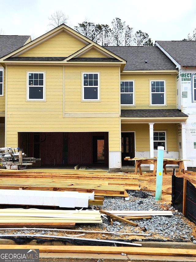 view of front facade with a deck and a shingled roof