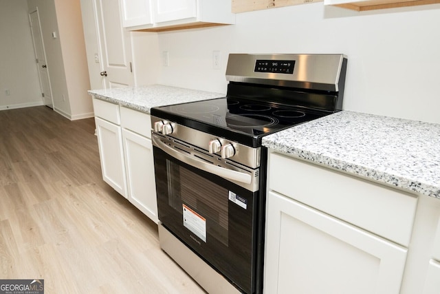 34 Russet Way Lot 57, Newnan, GA 30263 - kitchen with stainless steel range with electric cooktop, light wood-type flooring, white cabinets, and light stone counters