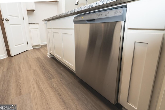 34 Russet Way Lot 57, Newnan, GA 30263 - kitchen view of stainless steel dishwasher, wood finished floors, white cabinets, and light stone countertops