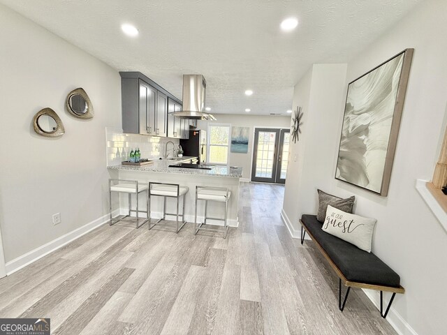 bathroom with a textured ceiling, toilet, wood finished floors, vanity, and vaulted ceiling