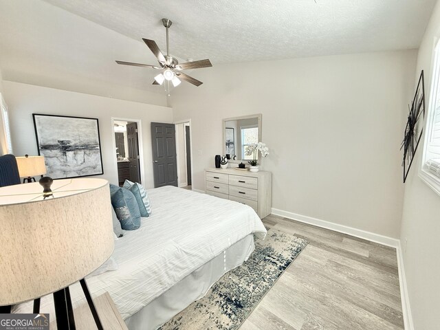 bathroom featuring a textured ceiling, wood finished floors, a sink, and visible vents