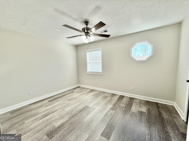 unfurnished room featuring light wood finished floors, a ceiling fan, and baseboards