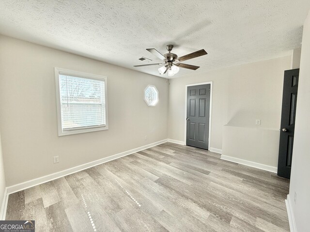 bathroom with a textured ceiling, toilet, wood finished floors, and vanity