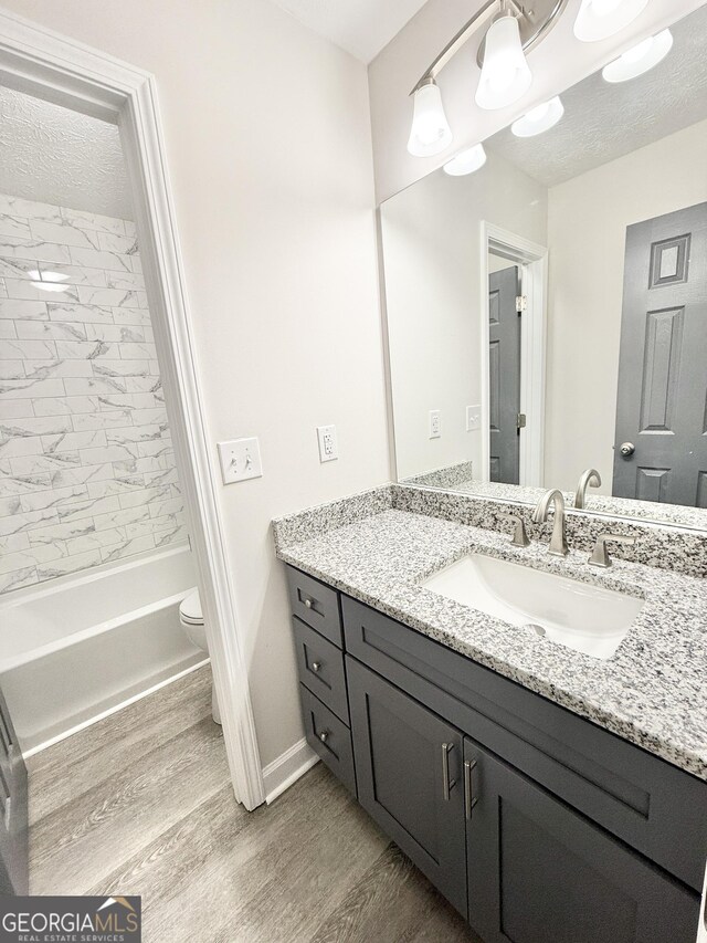 full bathroom featuring toilet, wood finished floors, and bathing tub / shower combination