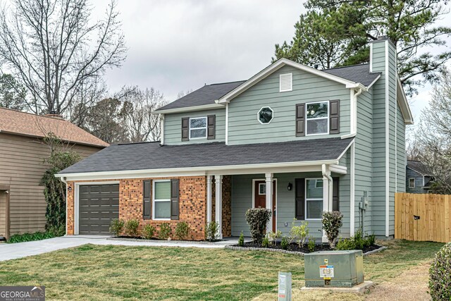 traditional-style house with a front lawn, a chimney, and an attached garage