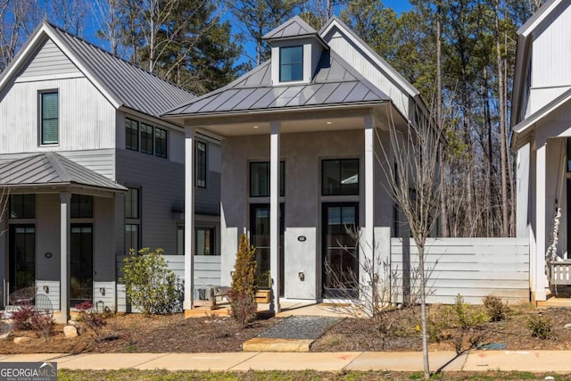 view of front of house featuring a porch, a standing seam roof, and metal roof