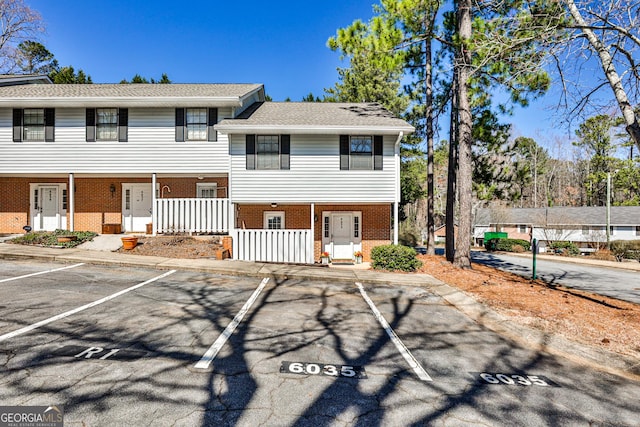 view of front of home featuring uncovered parking and brick siding