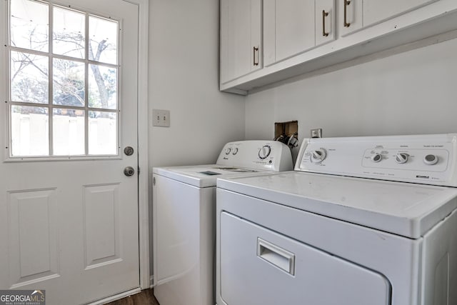 washroom with washing machine and clothes dryer and cabinet space