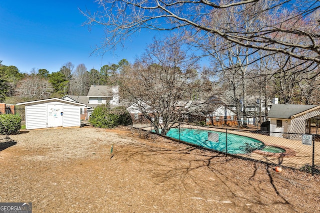 view of pool featuring an outbuilding, a pool with connected hot tub, fence, and a storage unit