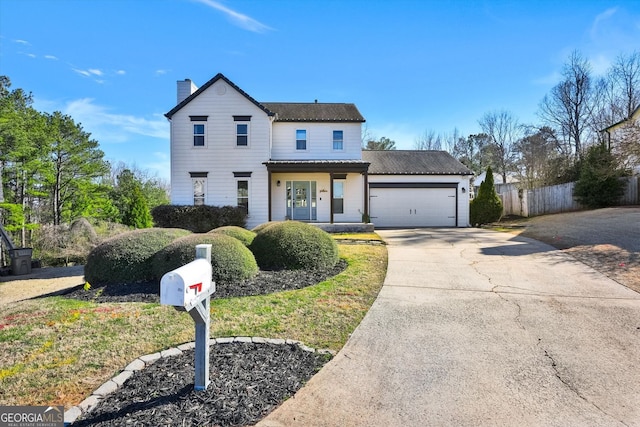 view of front of property featuring an attached garage, driveway, a chimney, and fence