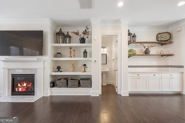 unfurnished living room featuring ornamental molding, dark wood-style flooring, visible vents, and built in features