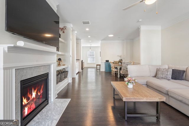 living area with a fireplace, recessed lighting, visible vents, dark wood-type flooring, and ornamental molding