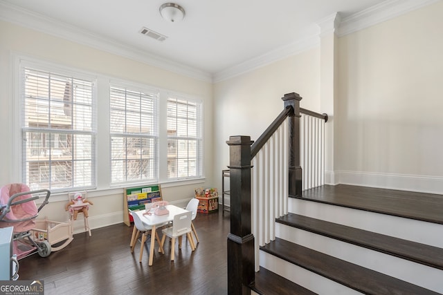 rec room with baseboards, visible vents, dark wood-style flooring, and ornamental molding