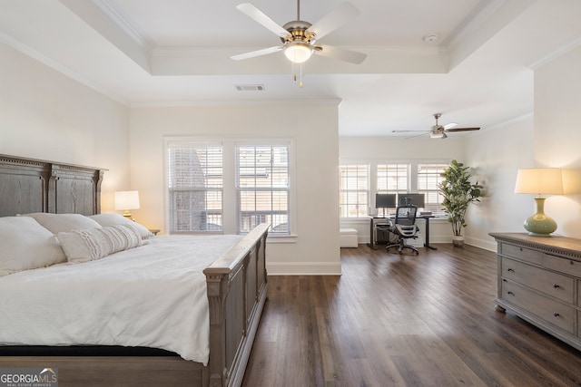 bedroom with dark wood-style floors, a tray ceiling, visible vents, and crown molding