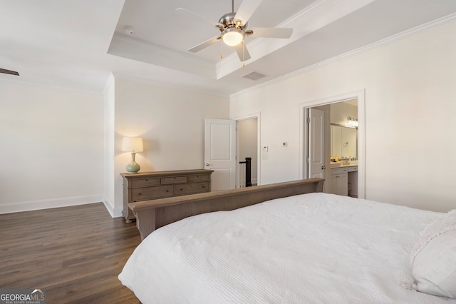 bedroom featuring dark wood-style flooring, visible vents, baseboards, ornamental molding, and a tray ceiling