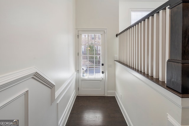 doorway with dark wood finished floors and baseboards