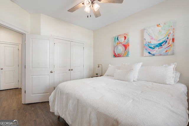 bedroom featuring dark wood-style floors, a ceiling fan, and a closet