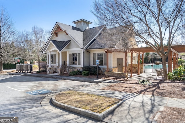 craftsman inspired home with a shingled roof, fence, a community pool, and a pergola