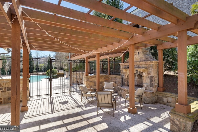 view of patio / terrace featuring an outdoor stone fireplace, fence, and a fenced in pool